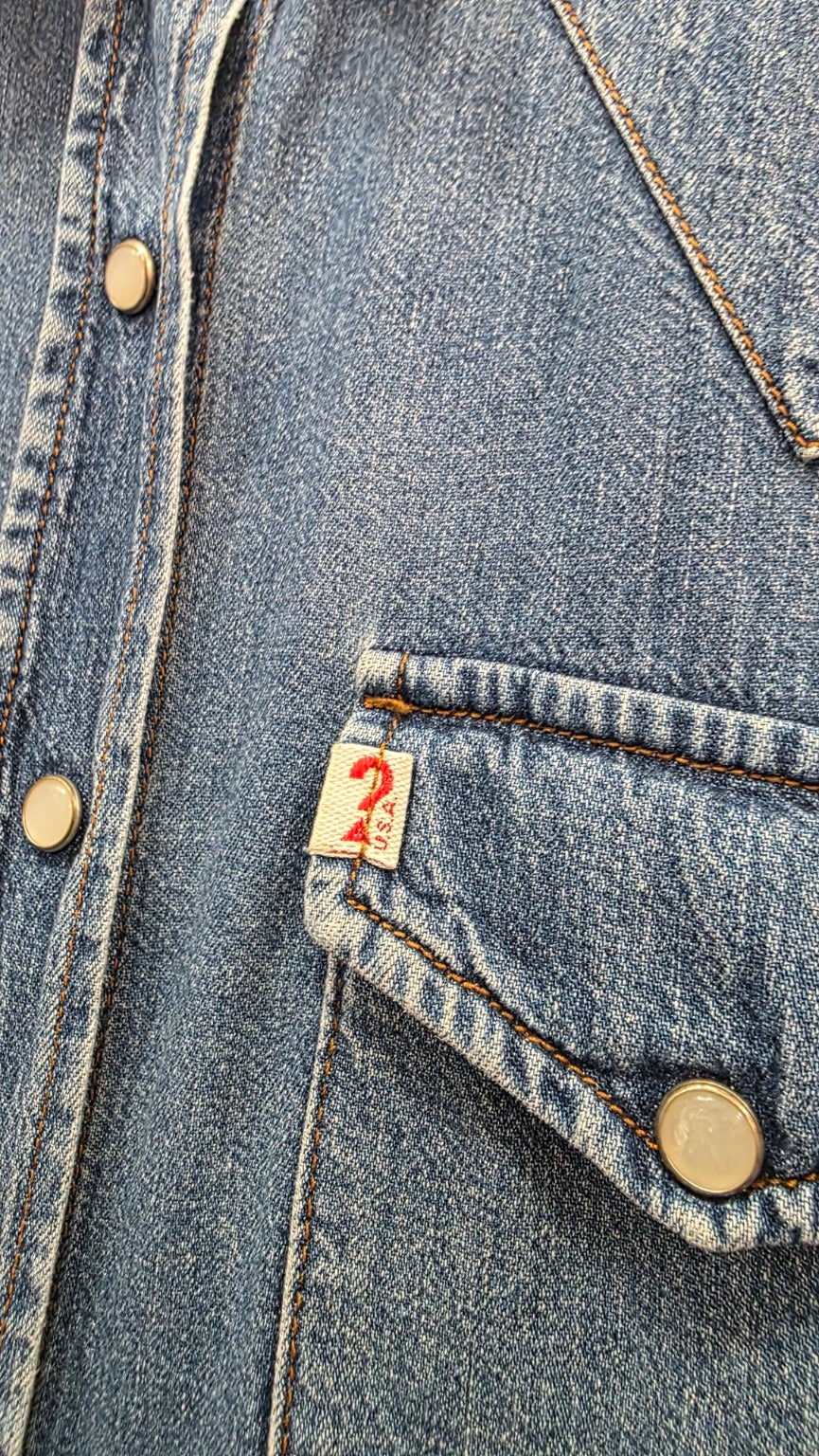 Dettaglio della tasca GUESS, delle cuciture a contrasto e dei bottoni effetto madreperlato