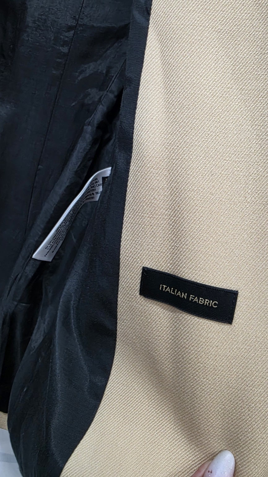Dettaglio della lana beige e dell'etichetta Italian Fabric