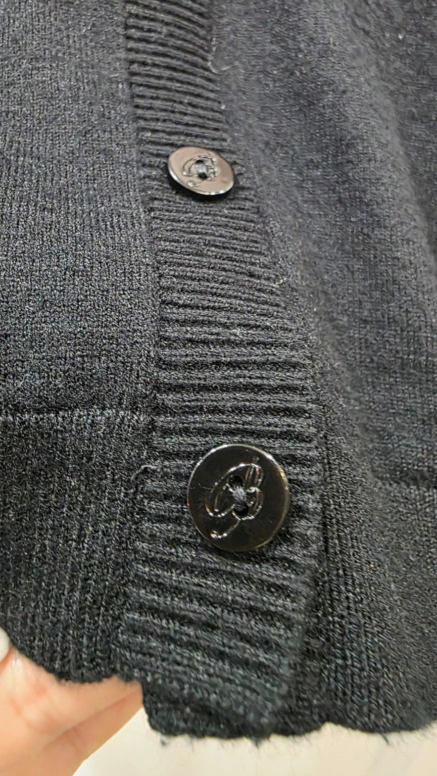 Dettaglio dei bottoni neri con monogramma B