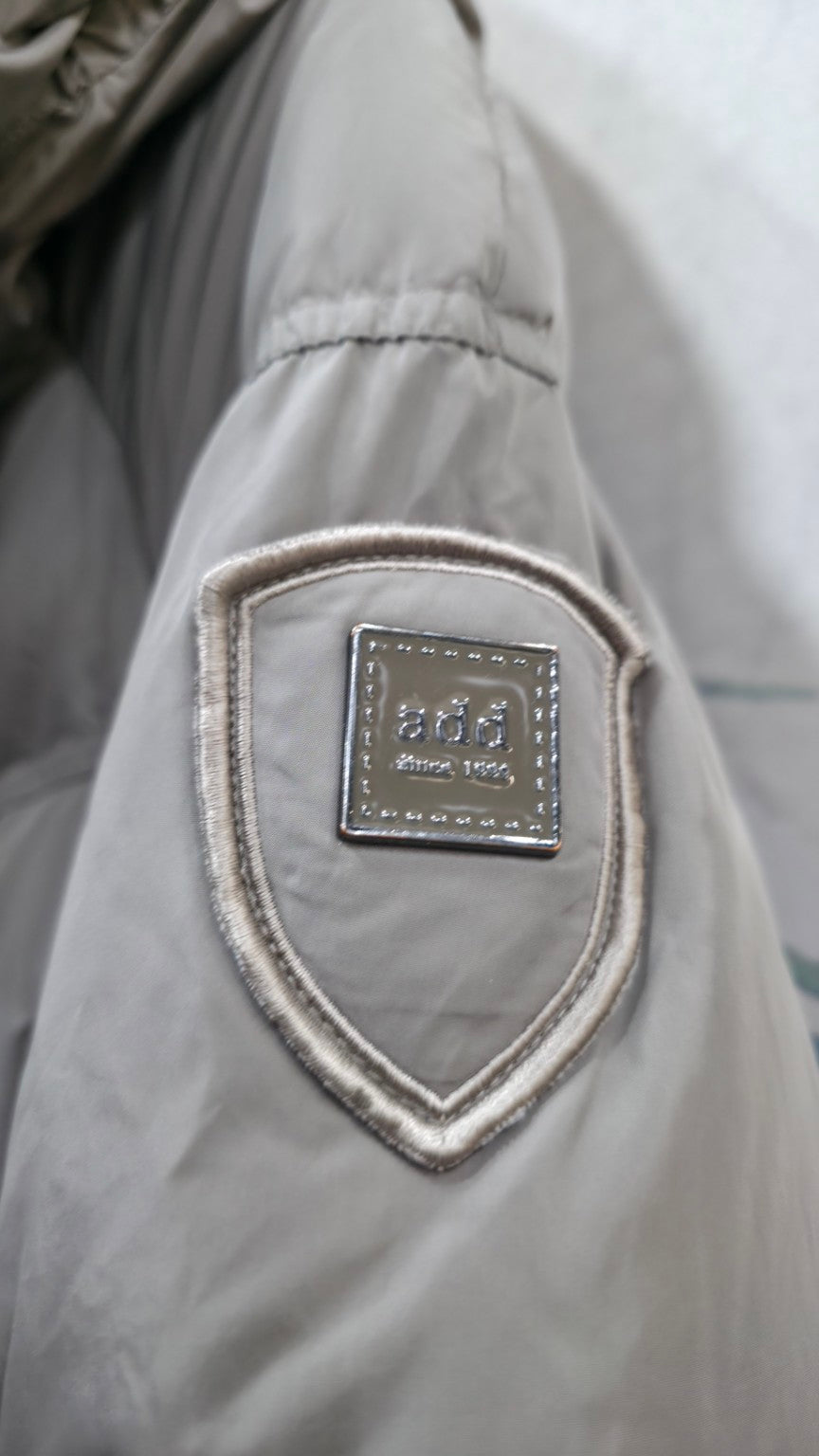 Piumino ADD – dettaglio reale del logo sulla manica
