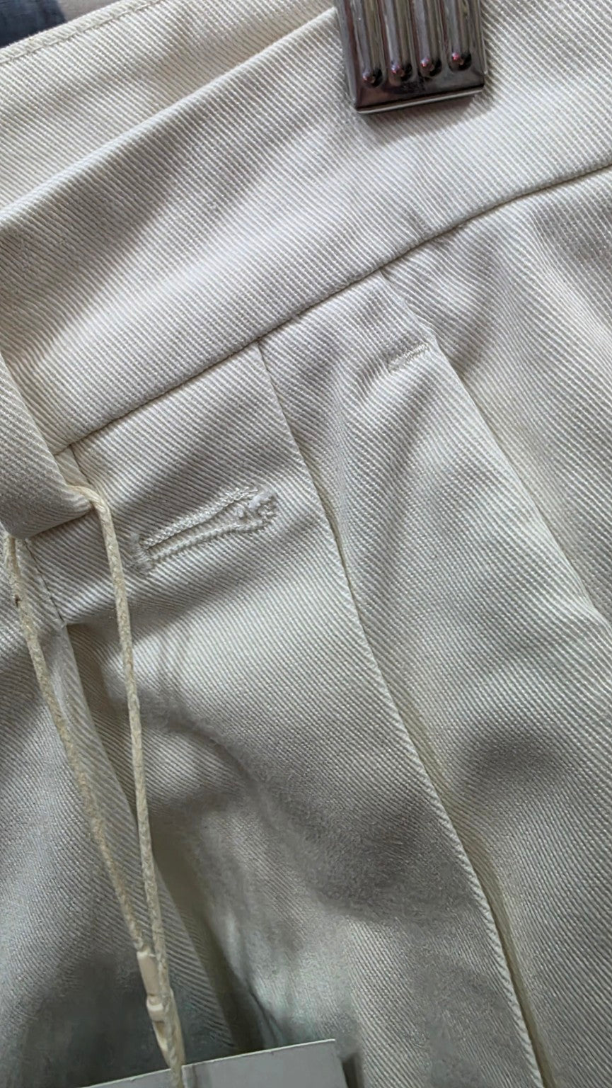 Dettaglio del bottone mancante sui pantaloni RED Valentino