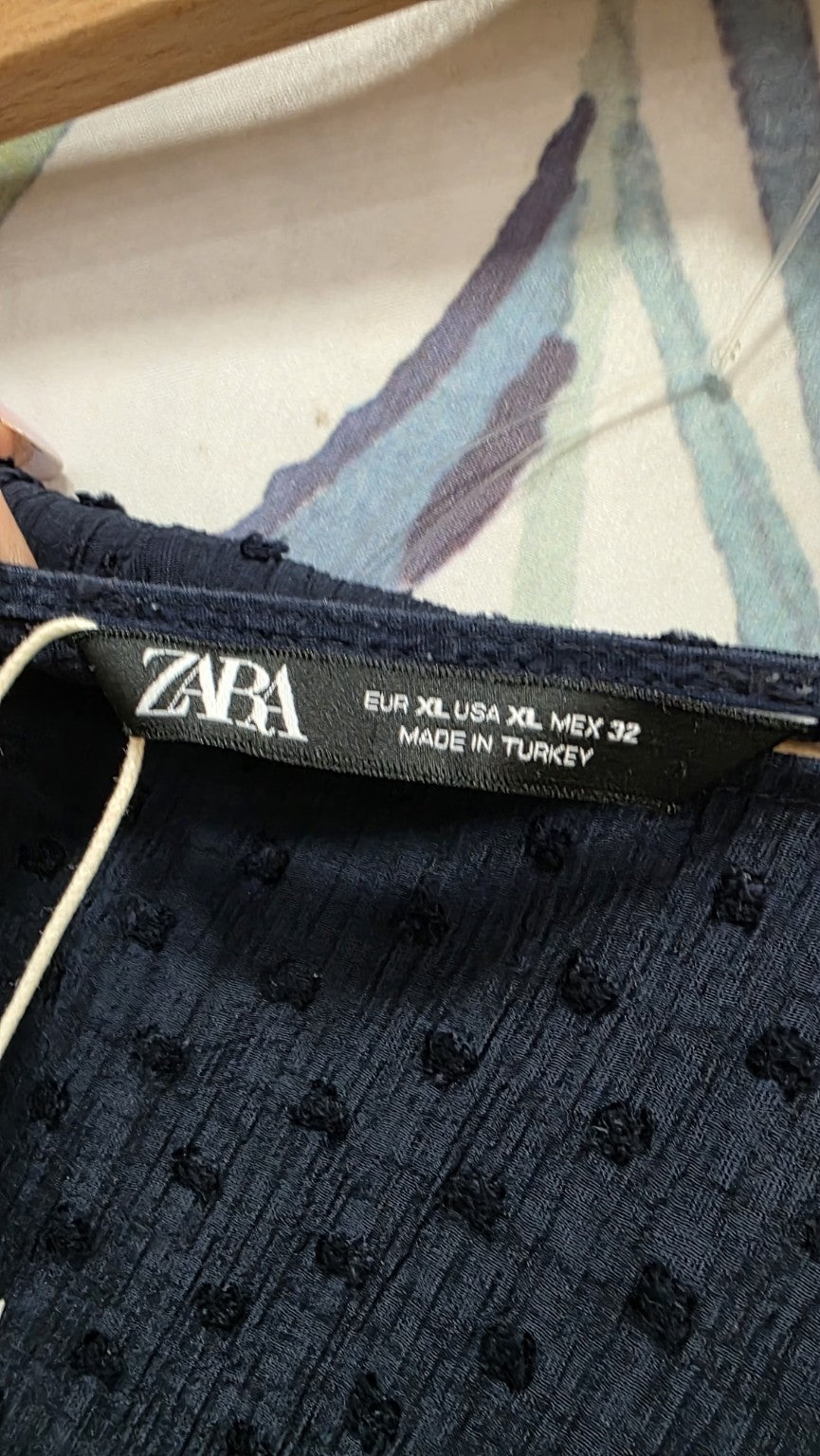 Etichetta Zara con taglia XL e dettaglio del tessuto blu
